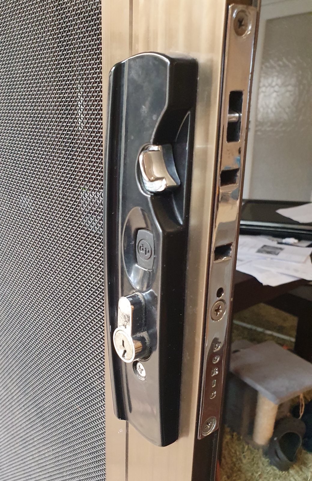 Recently repaired black security door handle and lock mechanism